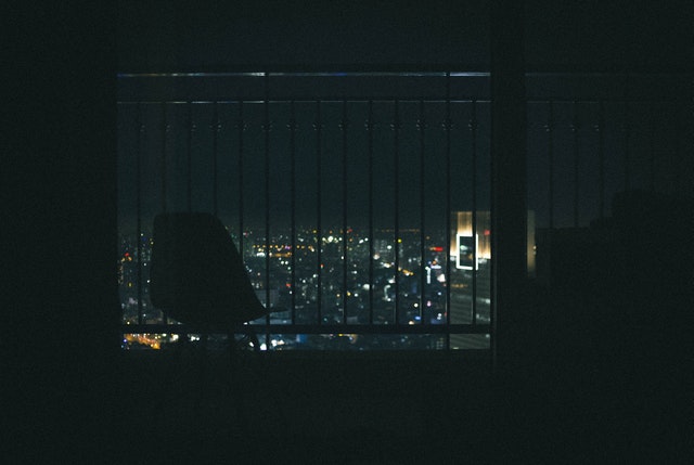Pohľad na nočné mesto cez balkón s nerezovým zábradlím.jpg