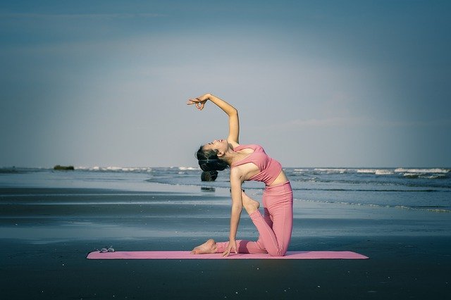 Žena v ružovom oblečení cvičí jogu